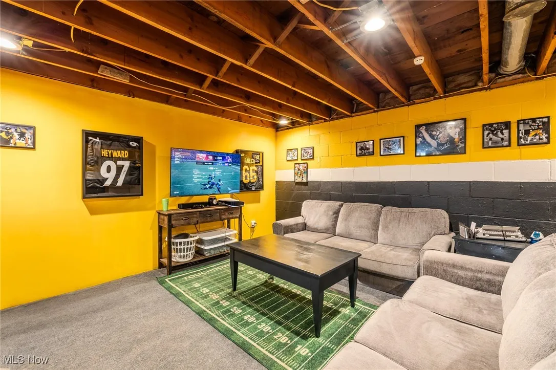 Living area with concrete block wall and carpet flooring