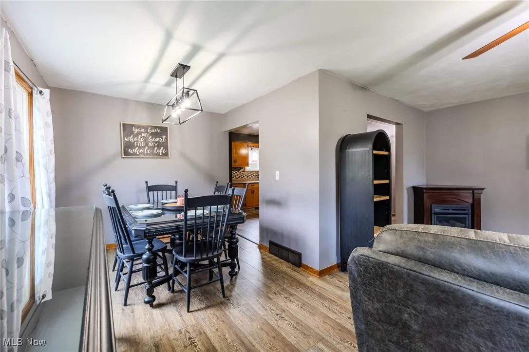 Dining area featuring wood finished floors and a fireplace