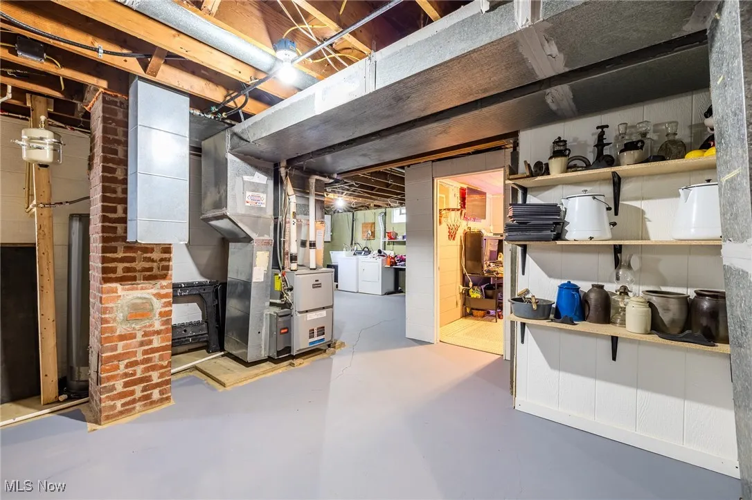 Unfinished below grade area with washing machine and dryer and heating unit