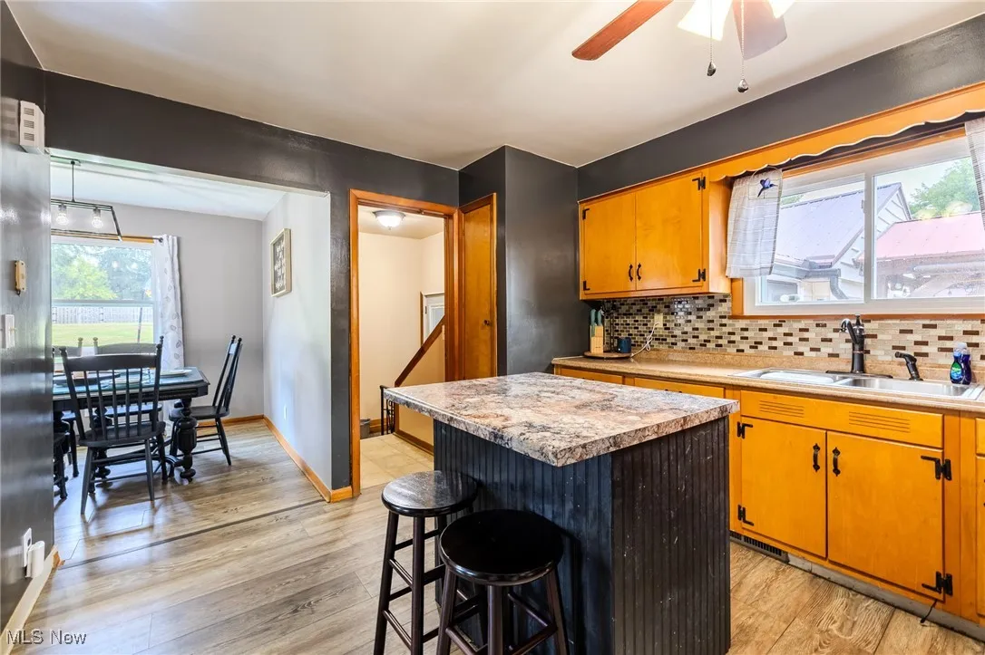 Kitchen featuring plenty of natural light, light countertops, a center island, and decorative backsplash