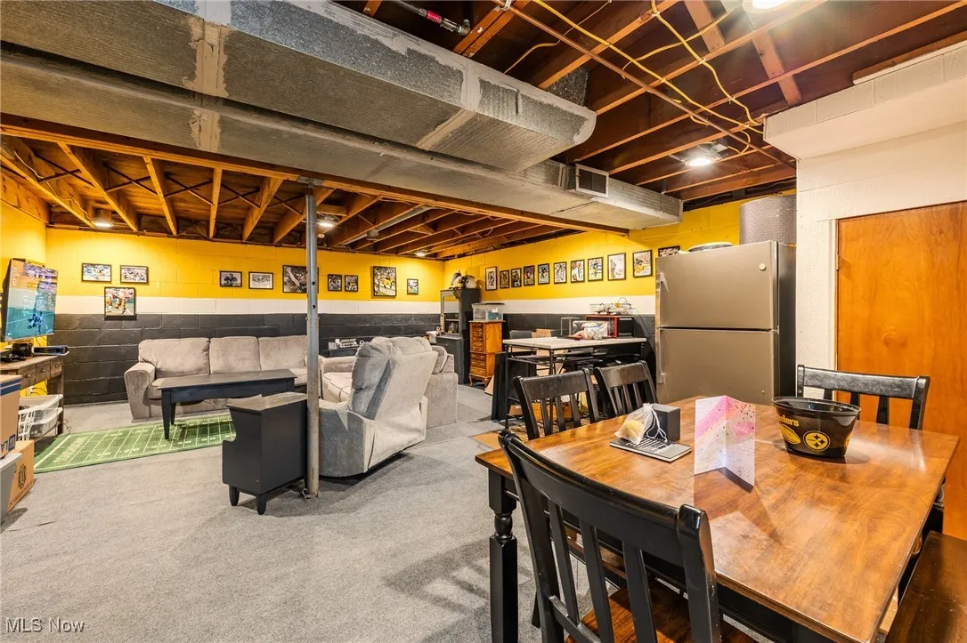 Carpeted dining space with concrete block wall