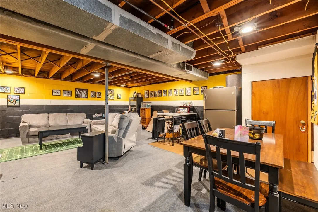 Carpeted dining room with concrete block wall