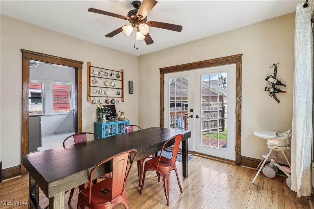 Dining room with light wood finished floors, a ceiling fan, and french doors