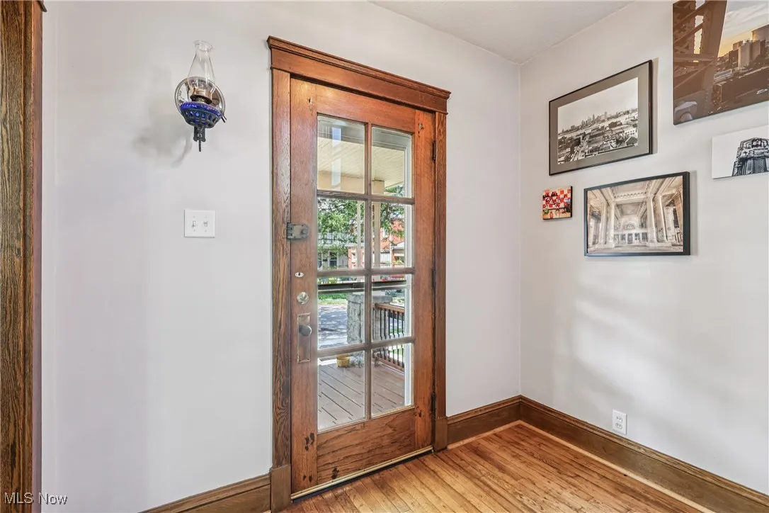 Doorway to outside featuring hardwood / wood-style floors and baseboards