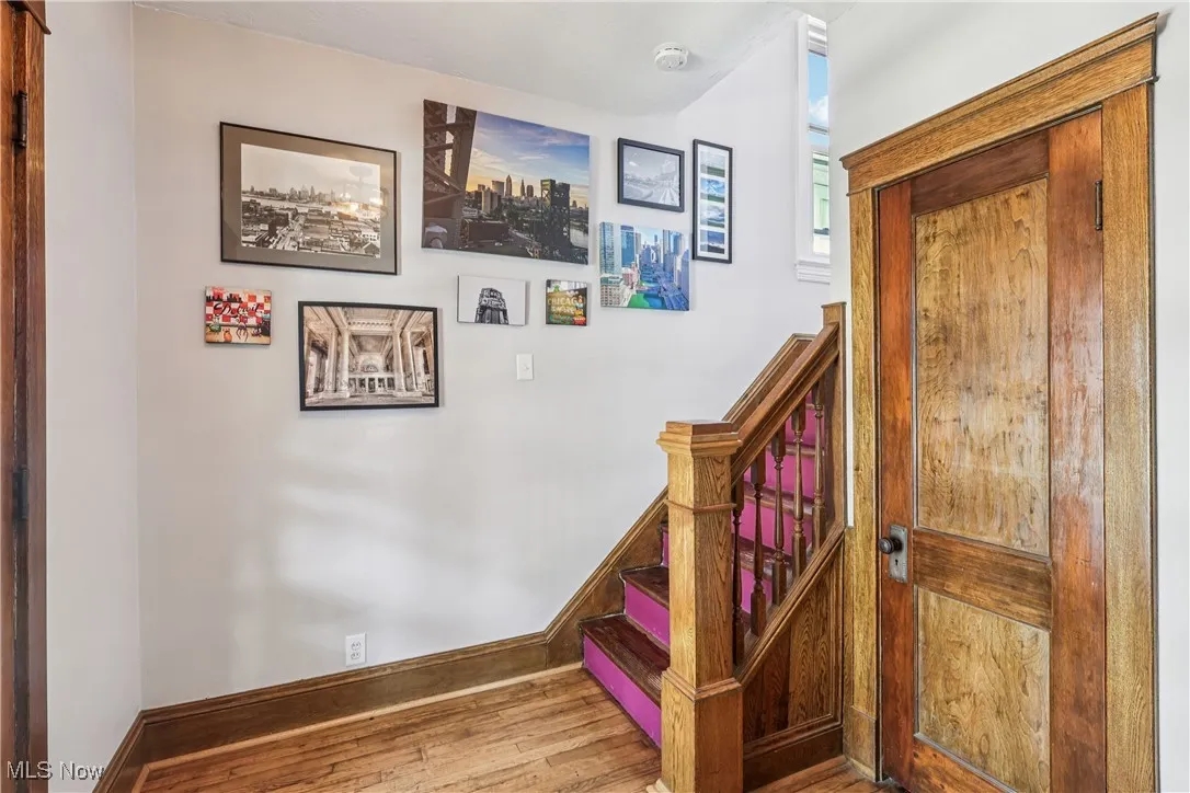 Stairs with wood finished floors and baseboards