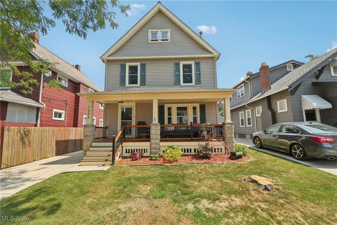 American foursquare style home featuring a front lawn and a porch