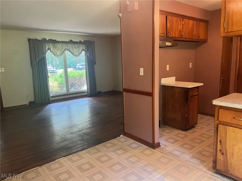 Kitchen featuring brown cabinets, light countertops and open to dining and living area