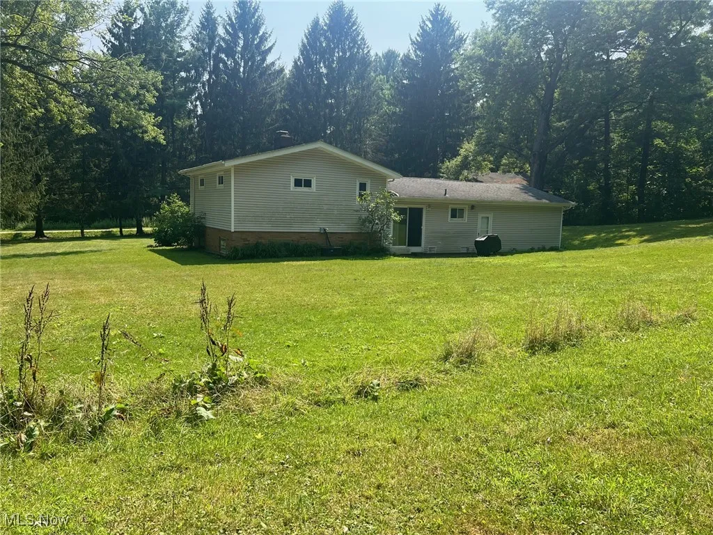 Back of house with a lawn