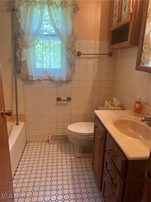 Bathroom featuring vanity, tile walls, and tile flooring
