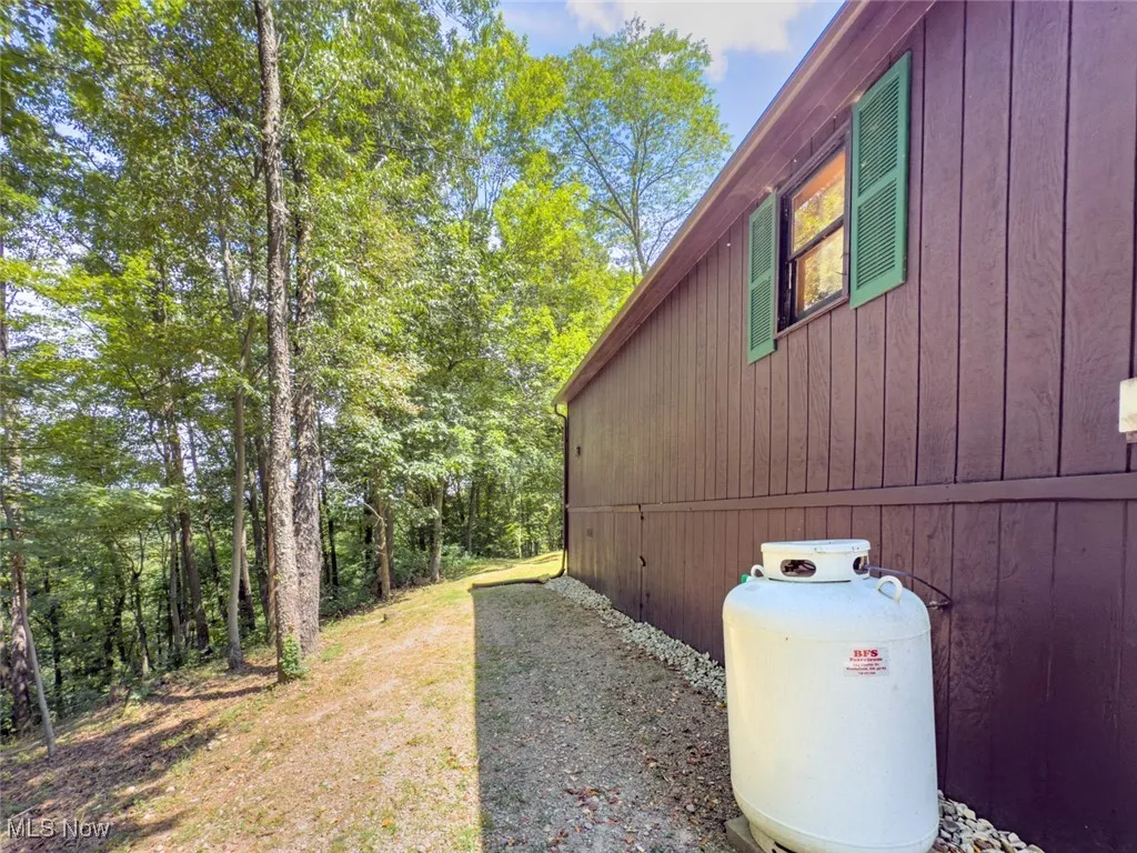 View of side of property featuring a view of trees