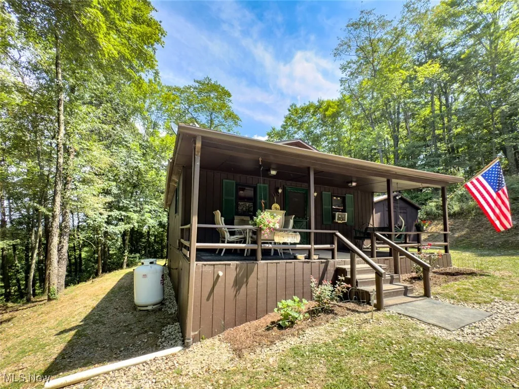 Chalet / cabin featuring board and batten siding, a front yard, and a porch