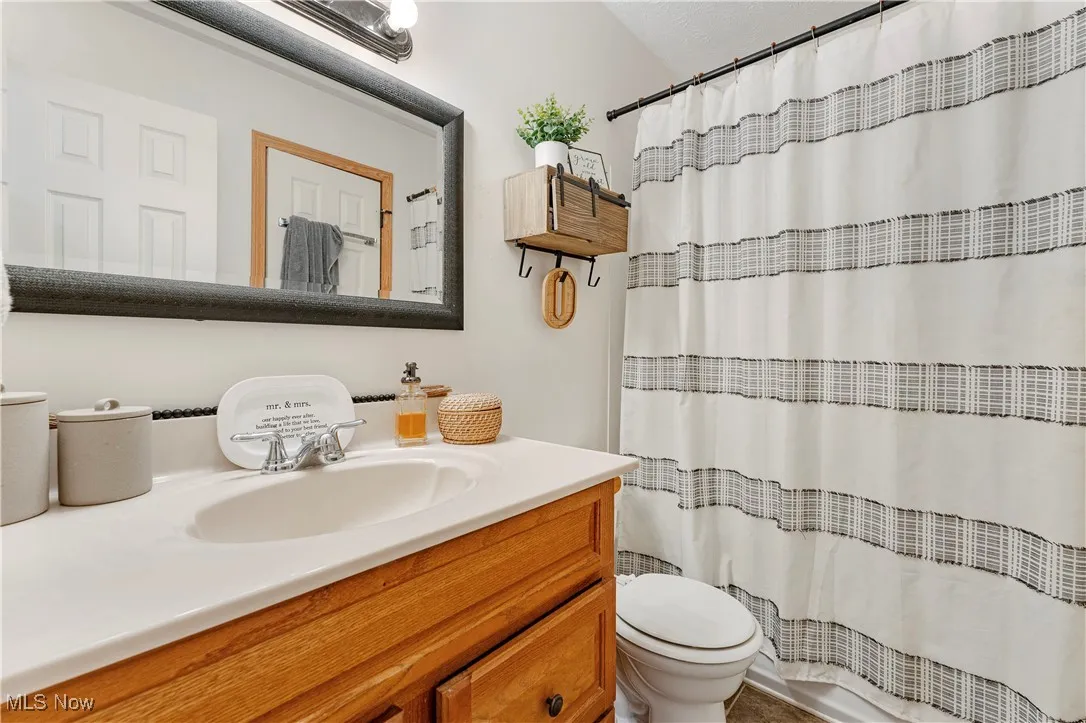 Bathroom featuring vanity and curtained shower