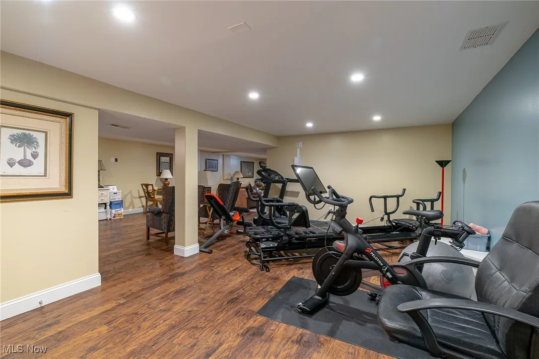 Exercise room featuring wood grained vinyl floors and recessed lighting