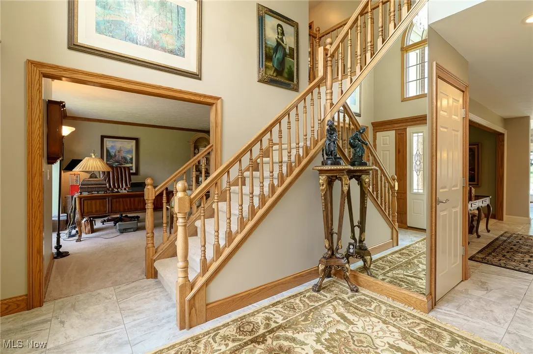 Stairs with tile  flooring and a high ceiling