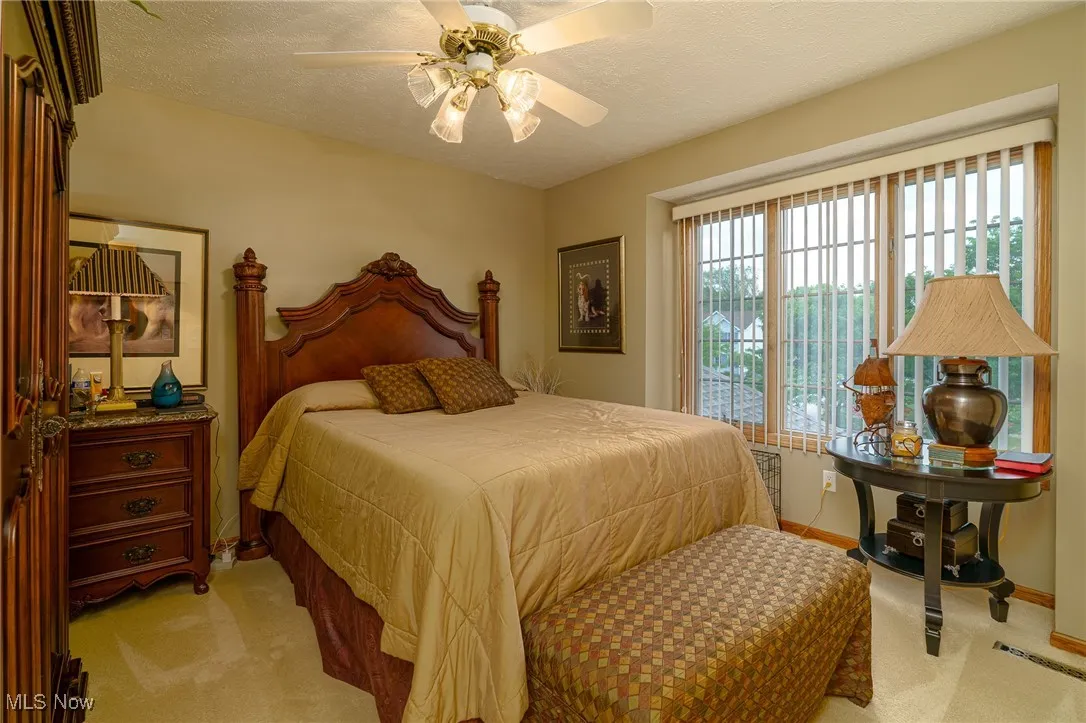 Bedroom featuring light colored carpet, and a ceiling fan