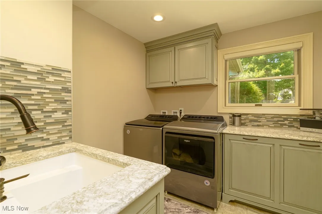 Laundry room featuring cabinet space, washer and dryer, and recessed lighting