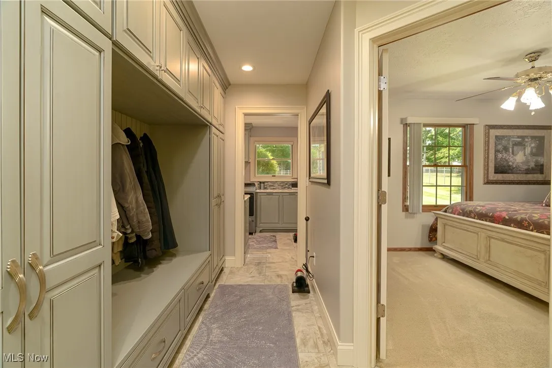 Mudroom featuring tile, recessed lighting, and custom built cabinetry.