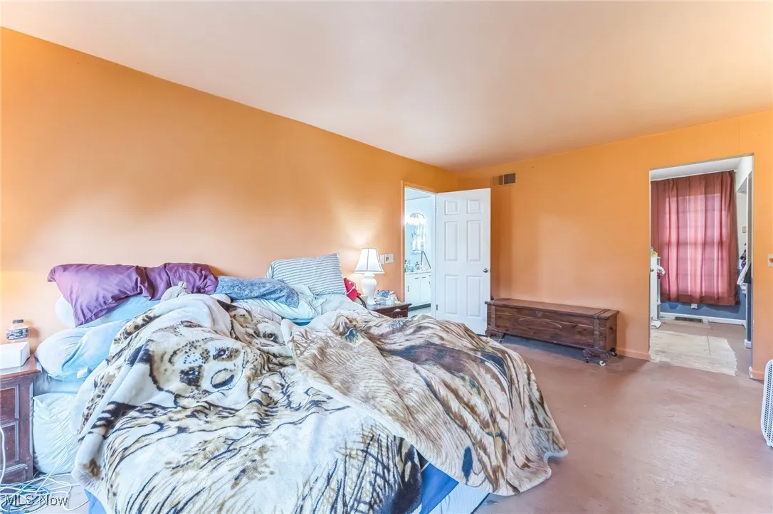 Bedroom with finished concrete flooring and baseboards
