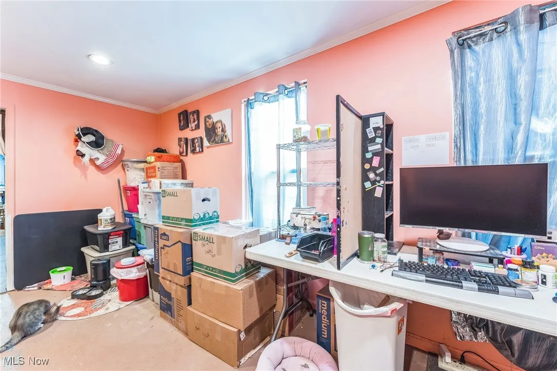 Home office with crown molding and concrete flooring