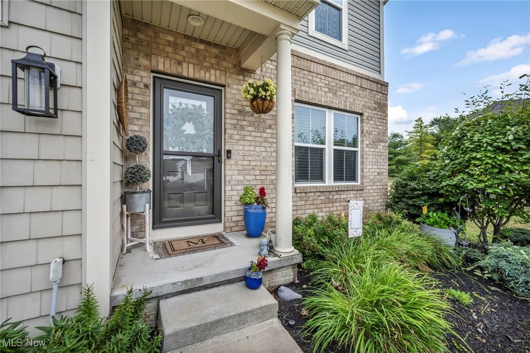 Doorway to property with brick siding and covered porch