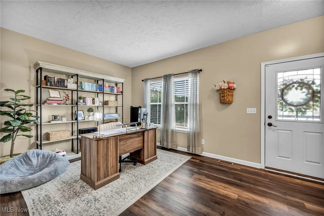 Home office with dark wood finished floors and a textured ceiling