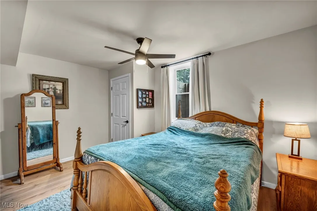Bedroom 5 in basement featuring light wood finished floors and ceiling fan