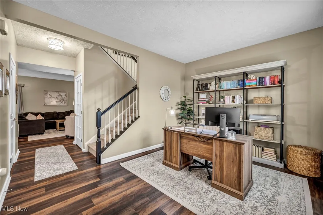 Office area with dark wood-style floors and a textured ceiling