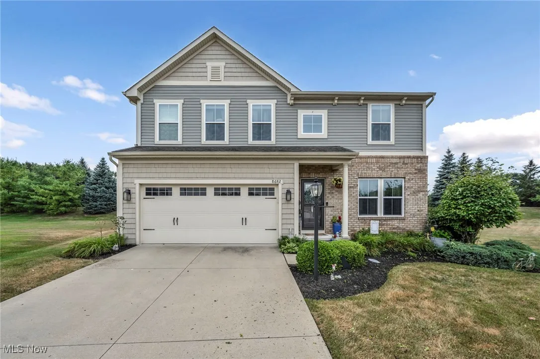 Traditional home with concrete driveway, a front yard, a garage, and brick siding