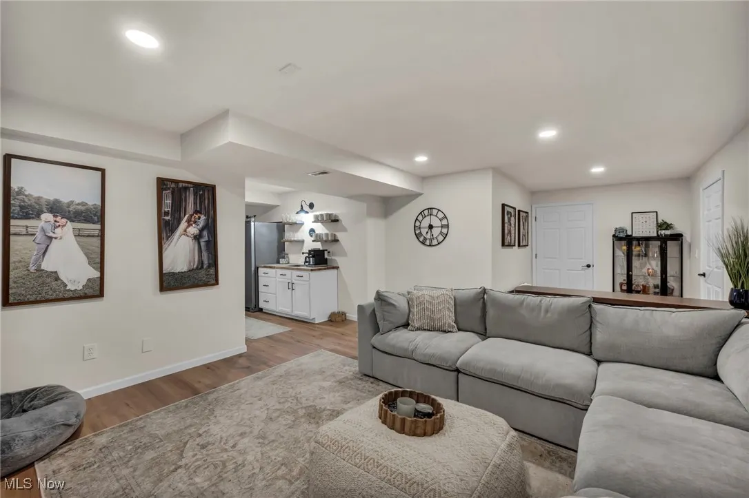 Recreation room  area with light wood-style floors and recessed lighting