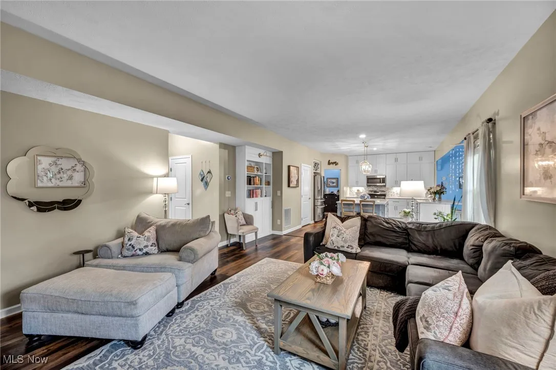 Living area with dark wood-style floors and baseboards