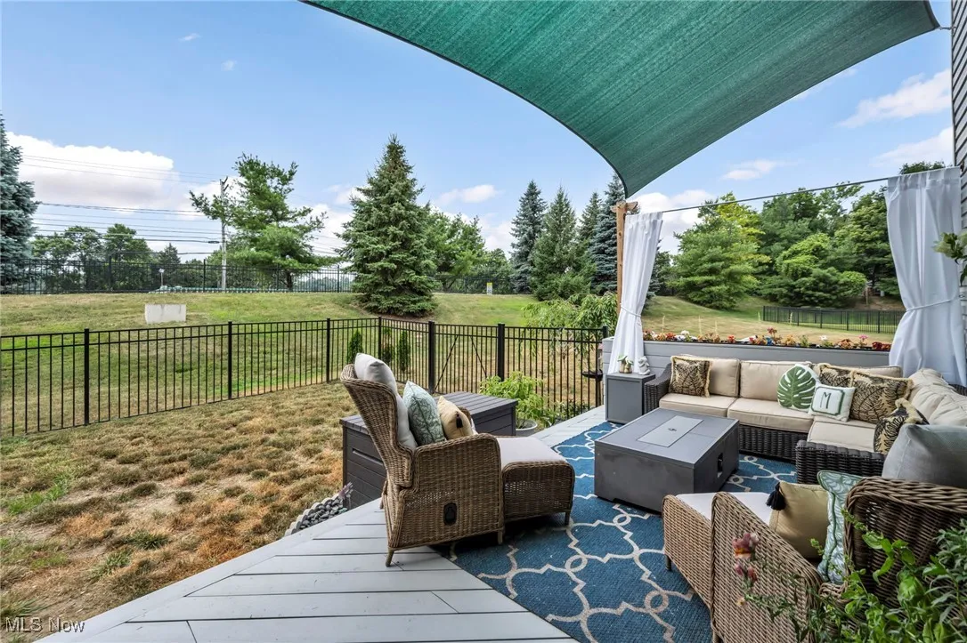 Deck with an outdoor living space and a fenced backyard off on kitchen