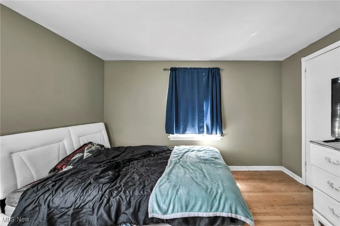 Bedroom featuring wood finished floors and baseboards