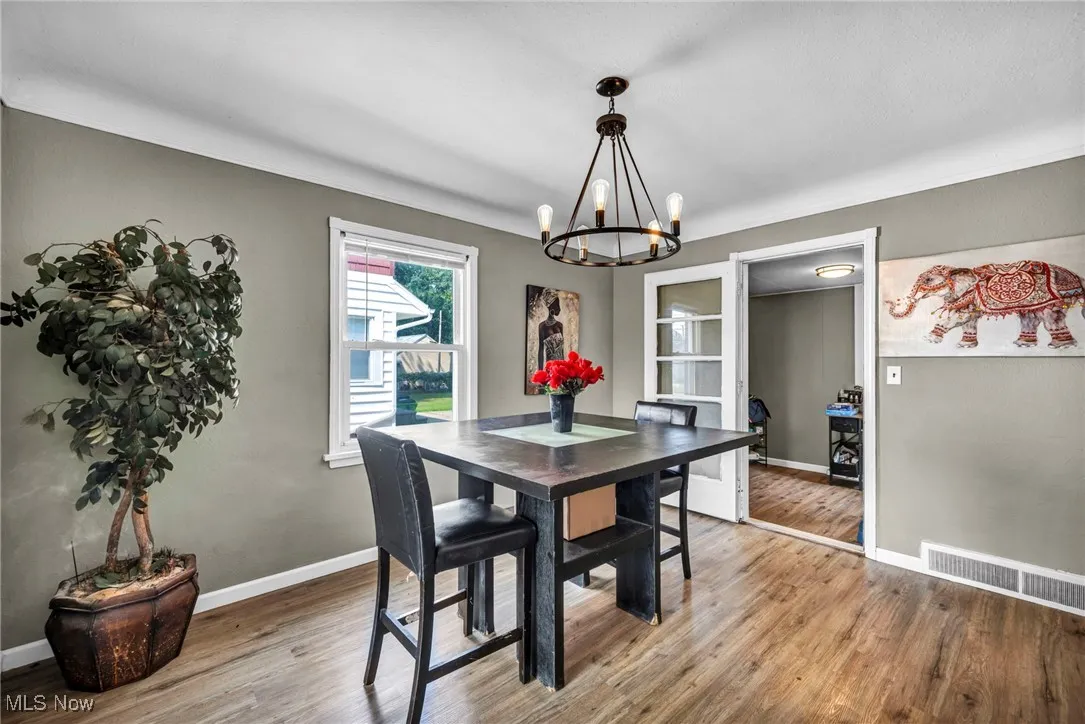 Dining space with light wood-style flooring and a chandelier