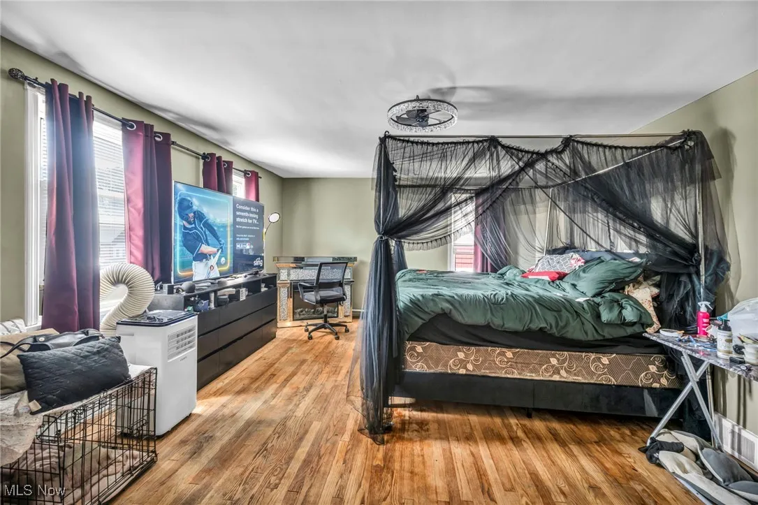 Bedroom featuring an office area and wood finished floors