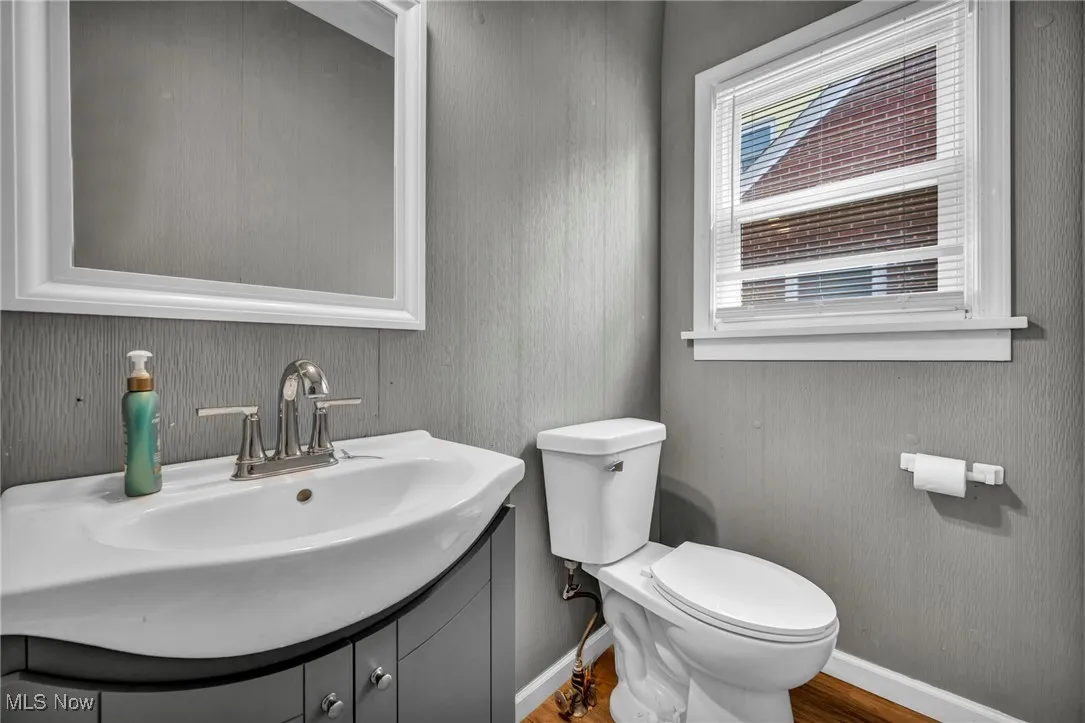 Half bath featuring vanity and wood finished floors