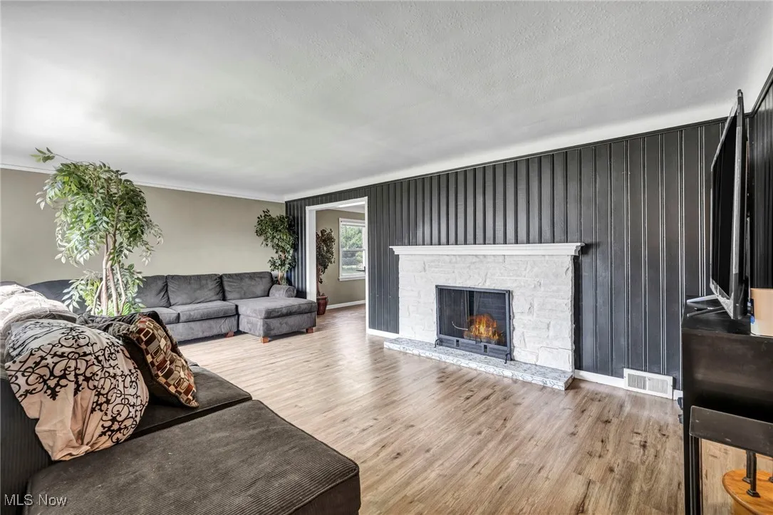 Living area featuring wood finished floors, a fireplace, and a textured ceiling