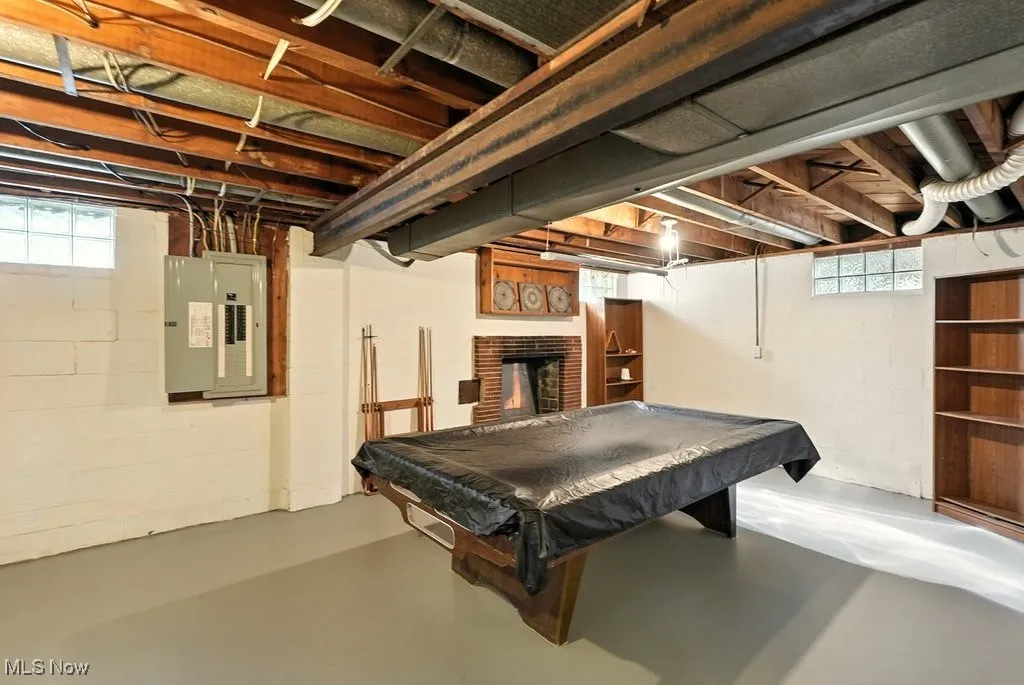 Rec featuring a brick fireplace, finished concrete flooring, billiards, and electric panel.