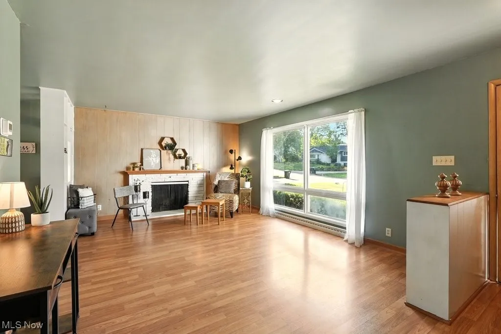 Living room with fireplace, bookcases, hardwood floor.