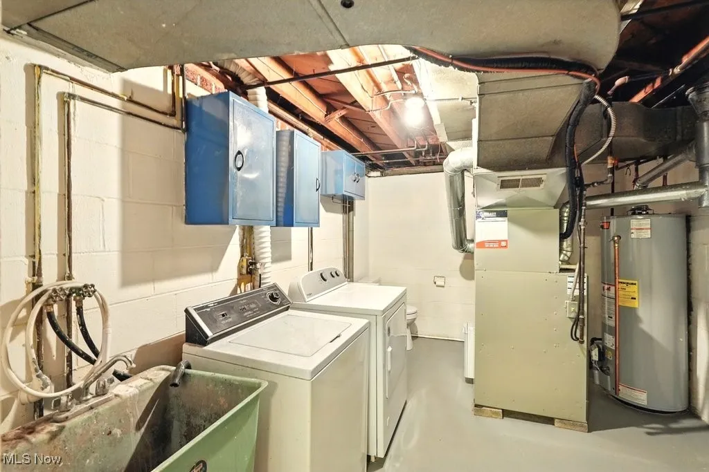 Washroom with washing machine and dryer, water heater, and heating unit and half bath