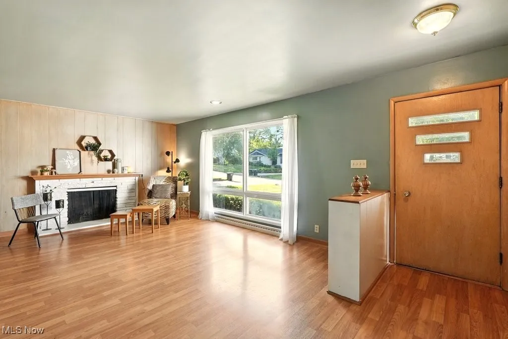 Living room with view of large front window, front door from porch.