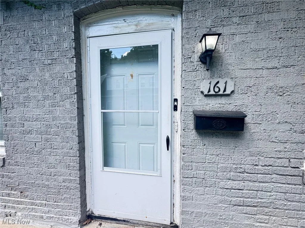 View of exterior entry with brick siding