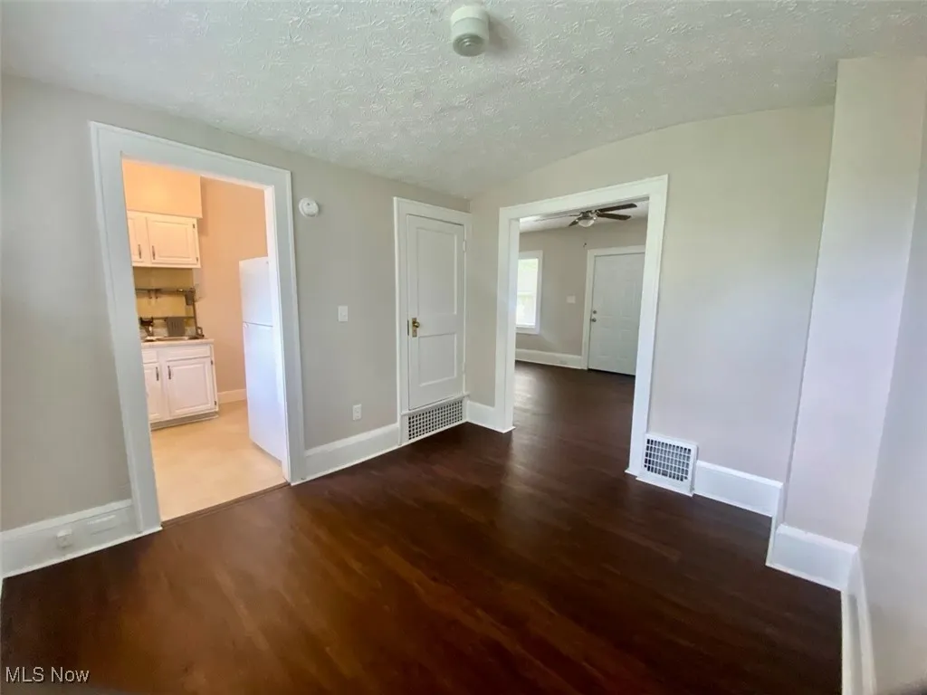 Unfurnished room featuring wood finished floors and a textured ceiling