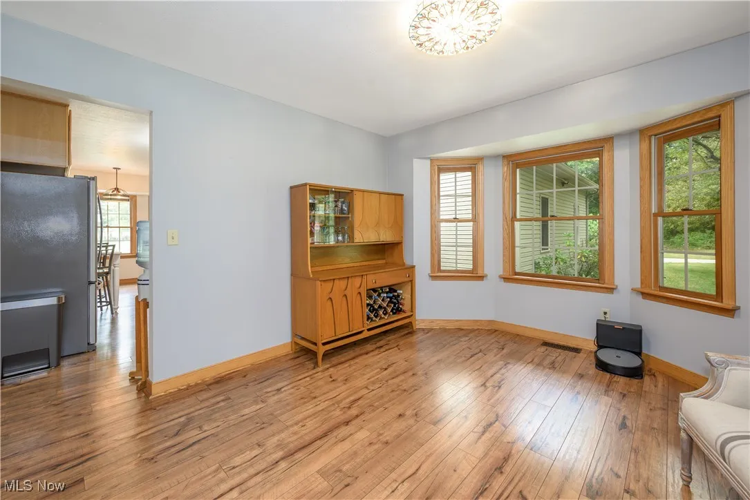 Unfurnished living room with wood-type flooring and baseboards