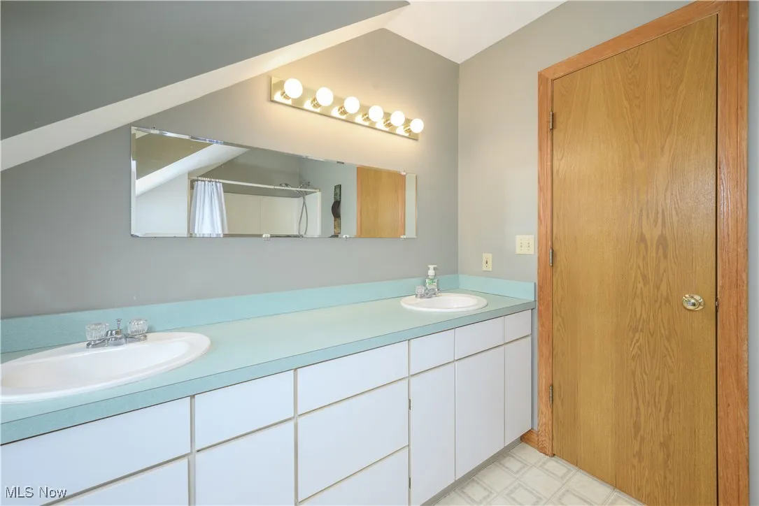 Bathroom with double vanity and tile patterned floors