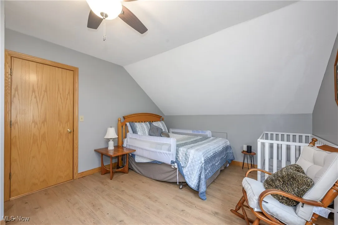 Bedroom featuring lofted ceiling, light wood-style floors, and ceiling fan