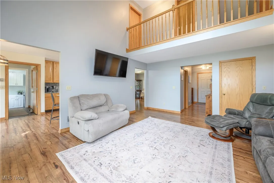 Living area featuring a high ceiling and light wood-style floors