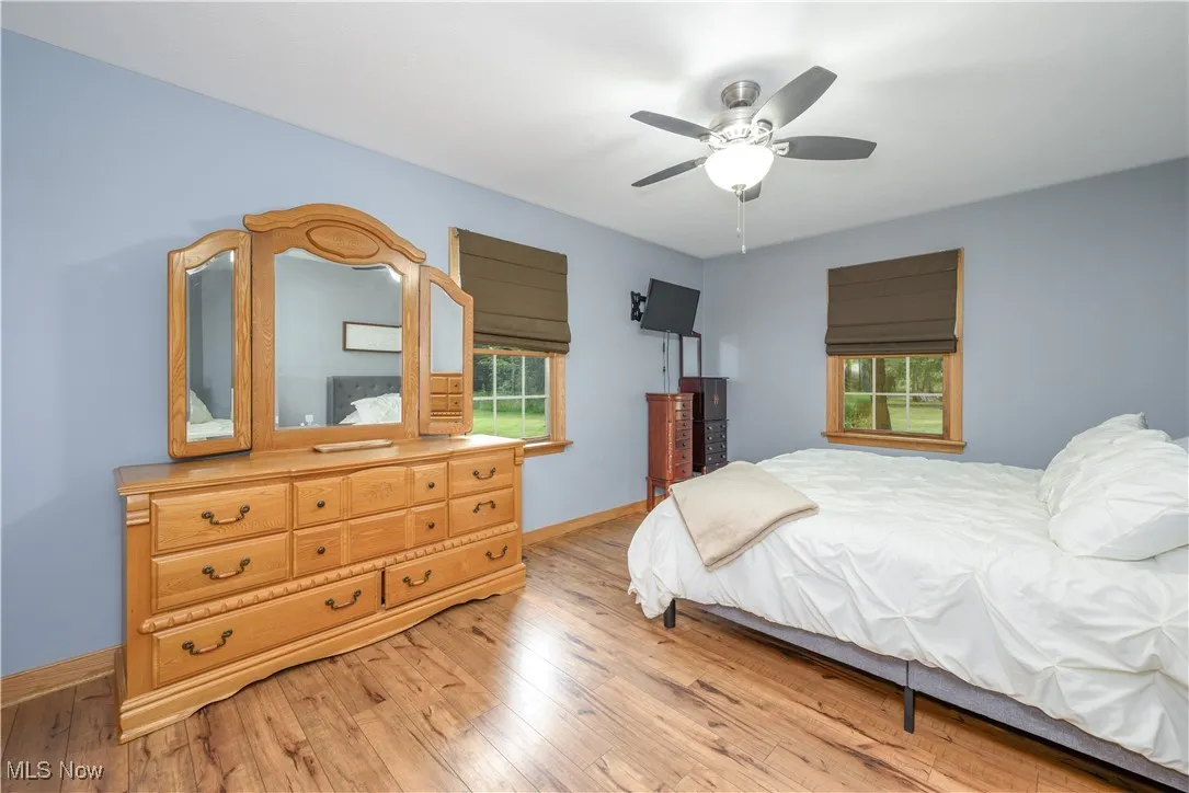 Bedroom featuring light wood-style floors, multiple windows, and a ceiling​​‌​​​​‌​​‌‌​‌‌​​​‌‌​‌​‌​‌​​​‌​​ fan