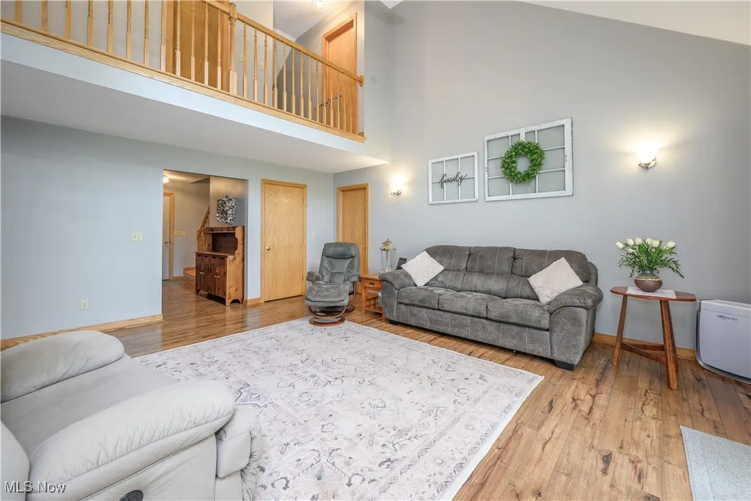 Living room featuring high vaulted ceiling and wood finished floors