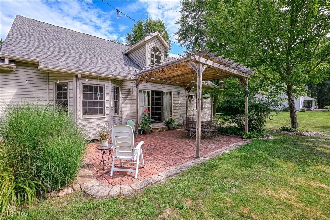 Rear view of property with a patio, a lawn, a pergola, and a shingled roof