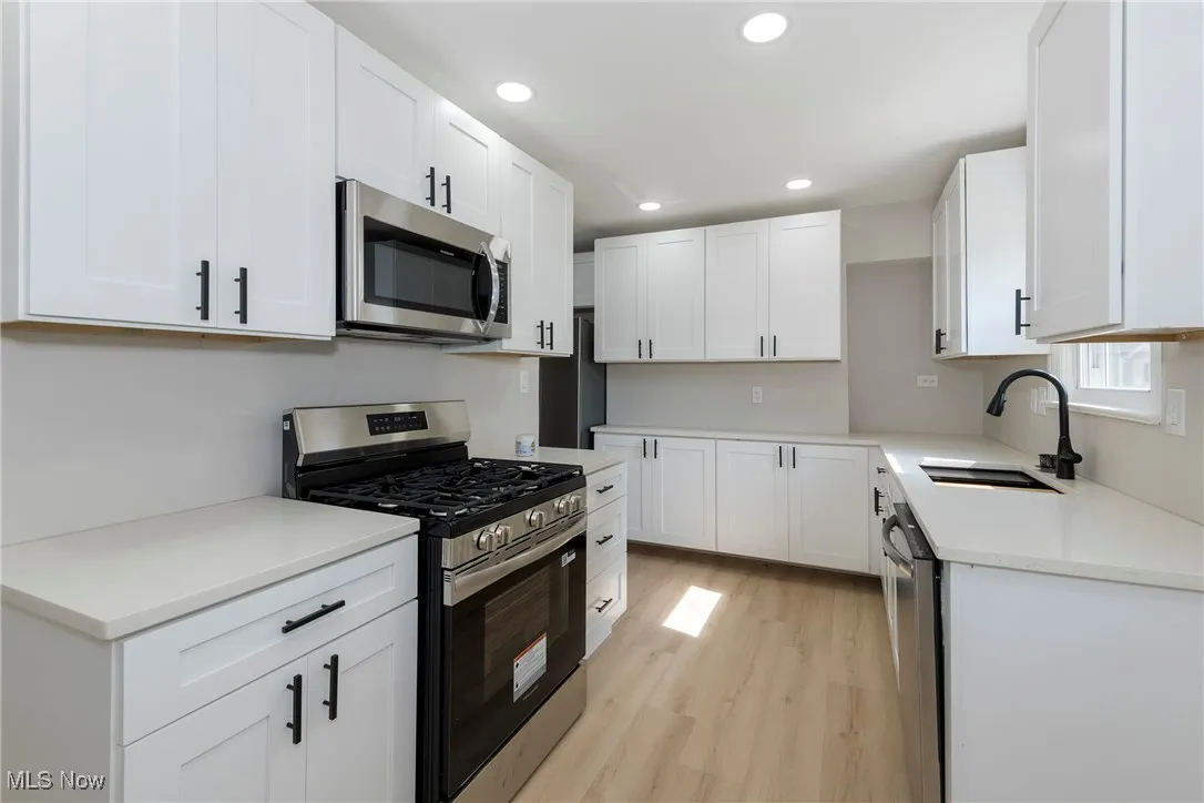 Kitchen featuring appliances with stainless steel finishes, light wood-type flooring, white cabinets, recessed lighting, and light countertops